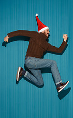 Image showing The running christmas man wearing a santa hat