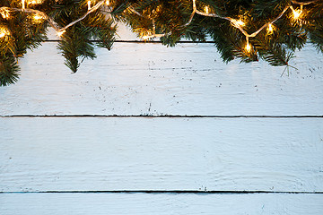 Image showing Christmas holiday wooden background with fir tree and golden garland