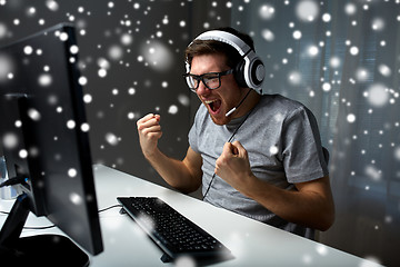 Image showing man in headset playing computer video game at home