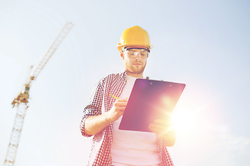 Image showing builder in hardhat with clipboard outdoors