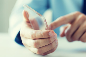 Image showing close up of male hand with transparent smartphone