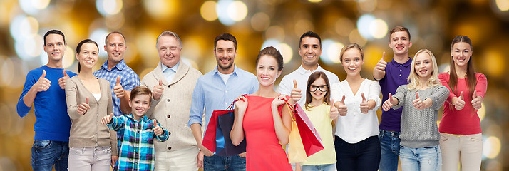 Image showing happy people with shopping bags showing thumbs up