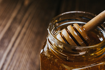 Image showing Close up of honey stick in jar