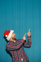 Image showing Surprised christmas man wearing a santa hat