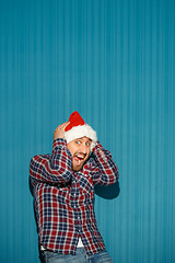 Image showing Surprised christmas man wearing a santa hat