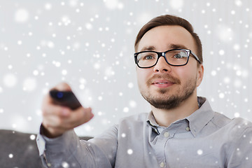 Image showing smiling man with tv remote control at home