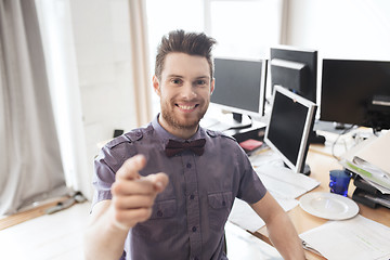 Image showing happy male office worker pointing finger at you