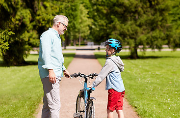 Image showing grandfather and boy with bicycle at summer park