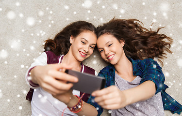 Image showing happy teenage girls on floor and taking selfie