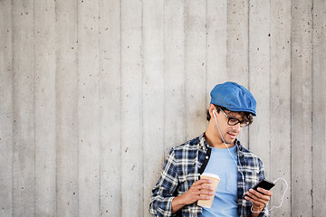 Image showing man with earphones and smartphone drinking coffee