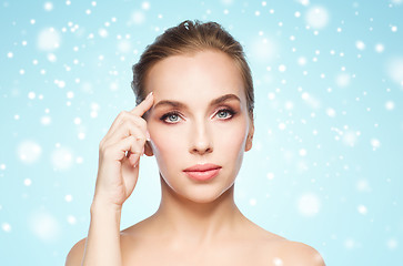 Image showing beautiful woman showing her forehead over snow