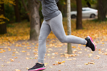 Image showing close up of young woman running in autumn park