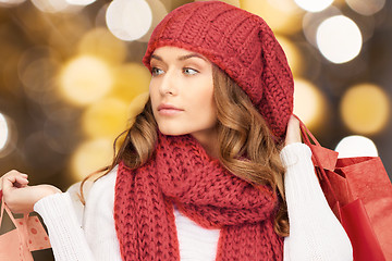 Image showing woman in red hat and scarf holding shopping bags