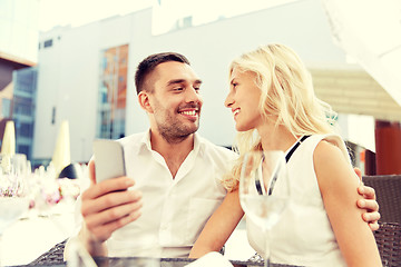 Image showing couple taking selfie with smatphone at restaurant