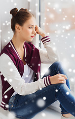 Image showing sad pretty teenage girl looking through window