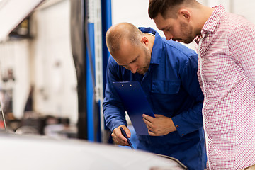 Image showing auto mechanic with clipboard and man at car shop