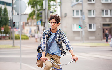 Image showing young hipster man with bag riding fixed gear bike