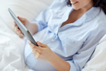 Image showing close up of pregnant woman with tablet pc at home