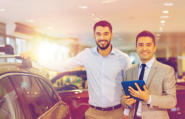 Image showing happy man with car dealer in auto show or salon