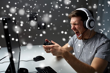 Image showing man in headset playing computer video game at home