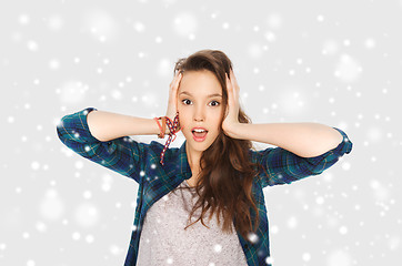 Image showing teenage girl holding to head over snow