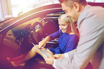 Image showing happy woman with car dealer in auto show or salon