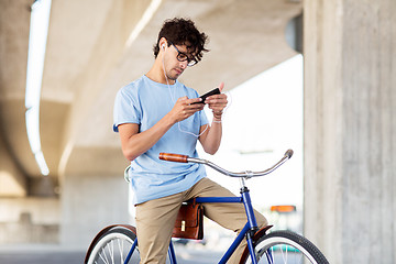 Image showing man with smartphone and earphones on bicycle