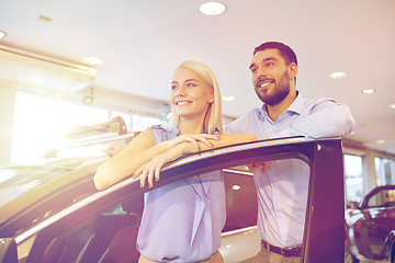 Image showing happy couple buying car in auto show or salon