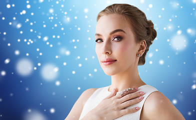 Image showing woman in white dress with diamond jewelry and snow