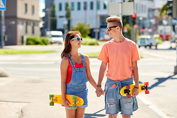 Image showing teenage couple with skateboards on city street