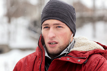 Image showing man with earphones listening to music in winter