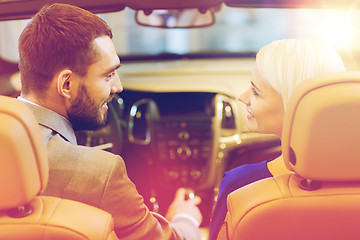 Image showing happy couple sitting in car at auto show or salon