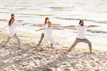 Image showing people making yoga in warrior pose on beach