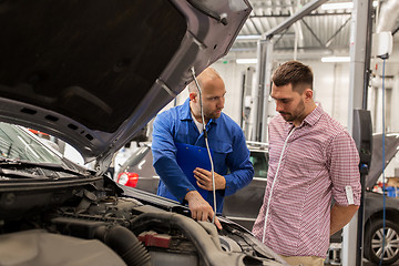 Image showing auto mechanic with clipboard and man at car shop