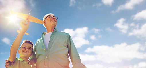 Image showing senior man and boy with toy airplane over sky