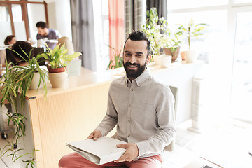 Image showing happy creative male office worker with folfer