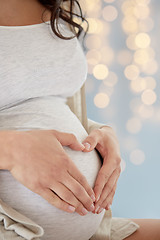 Image showing close up of pregnant woman making heart gesture