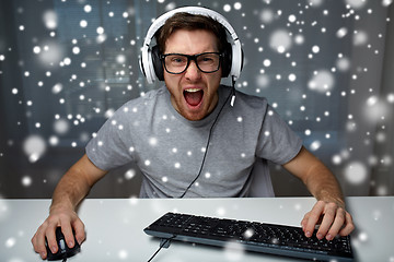 Image showing man in headset playing computer video game at home