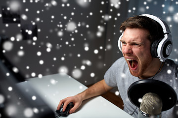 Image showing man in headset playing computer video game at home