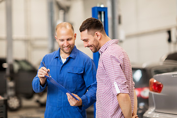 Image showing auto mechanic with clipboard and man at car shop