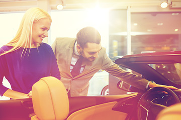 Image showing happy couple buying car in auto show or salon