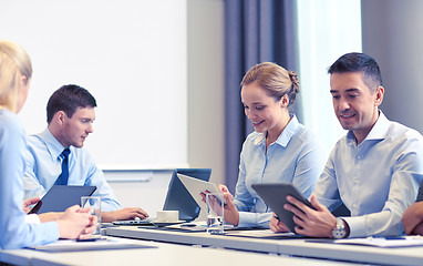 Image showing smiling business people with tablet pc in office