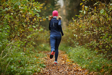 Image showing Young blonde runs among trees