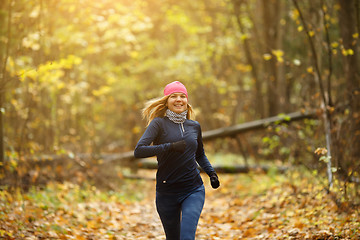 Image showing Blonde woman jogging in morning in autumn park