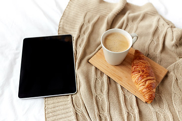 Image showing tablet pc, coffee and croissant on bed at home