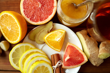 Image showing ginger tea with honey, citrus and garlic on wood