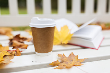Image showing coffee drink in paper cup on bench at autumn park