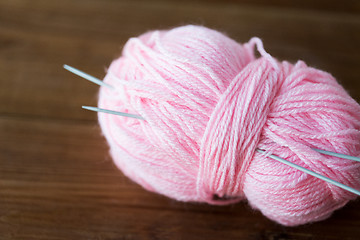 Image showing knitting needles and ball of pink yarn on wood