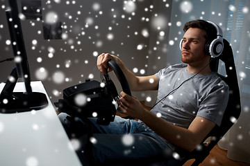 Image showing man playing car racing video game at home