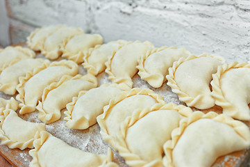 Image showing Uncooked dumplings on the kitchen board 